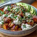 A finished Hot Honey Sweet Potato Bowl garnished with cilantro and pumpkin seeds, ready to serve for lunch.