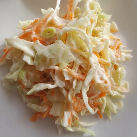 A creamy, tempting Coleslaw with Apple, boasting a light dressing and crisp, colorful vegetables, perfect for summer.