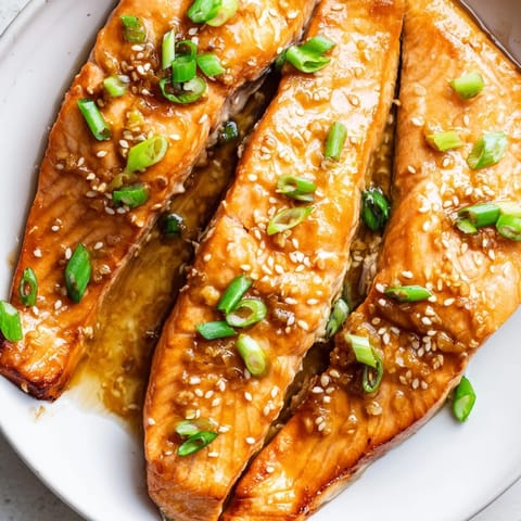Close-up of flaky Honey Garlic Salmon with a savory glaze; imagine the rich, sweet aroma.