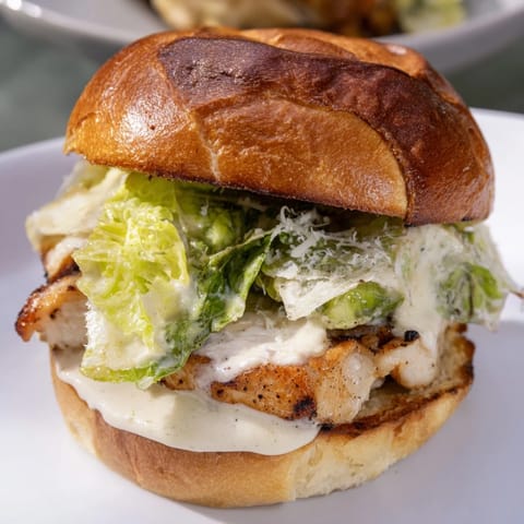 Juicy Caesar chicken sandwich layered with fresh lettuce and Parmesan on a golden bun.