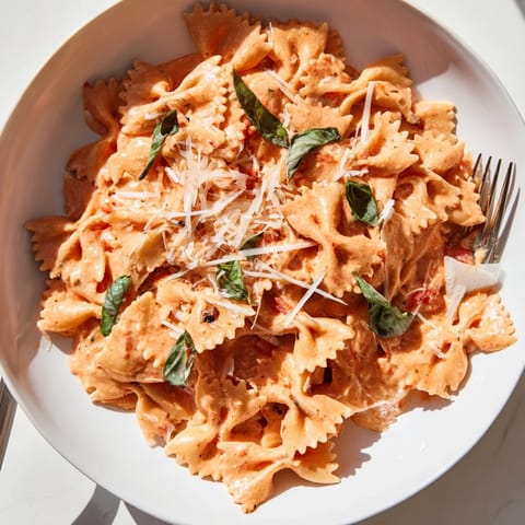 A warm skillet of homemade tomato basil bowtie pasta with a silky red sauce, ready to serve.