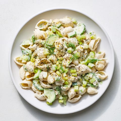 Chilled Cucumber Crunch Pasta Salad tossed with tangy dressing, everything bagel seasoning, and bright green onions, ready to serve.