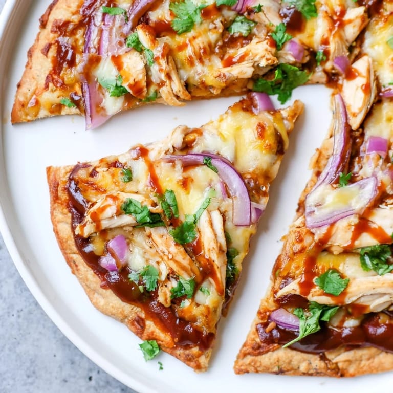 Homemade Chicken BBQ Pizza boasting grilled chicken, red onions, delicious melted cheese, ready to eat.