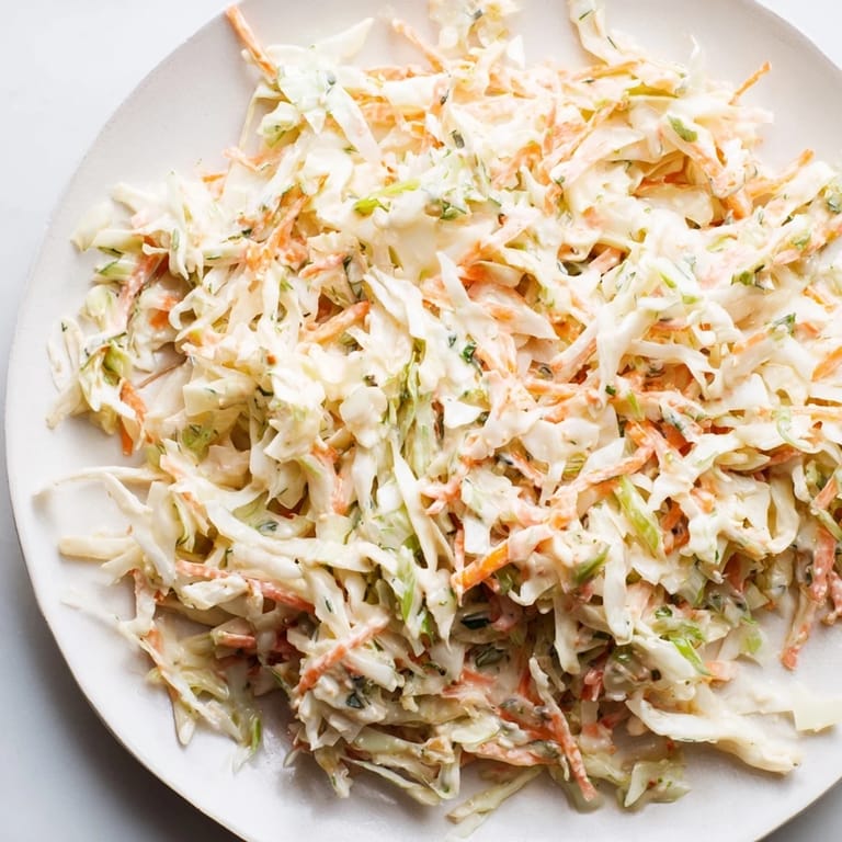 Enjoy a bowl of tangy Coleslaw with Apple, a beautiful mix of textures and flavors, ready to serve and savor.