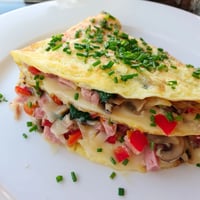 A golden-brown Omelet with Cheese, perfectly folded with creamy melted cheese, ready to eat.