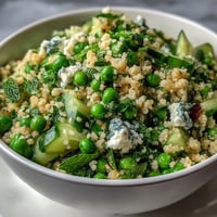 A vibrant spring pea and mint couscous salad with fresh herbs and crisp vegetables.
